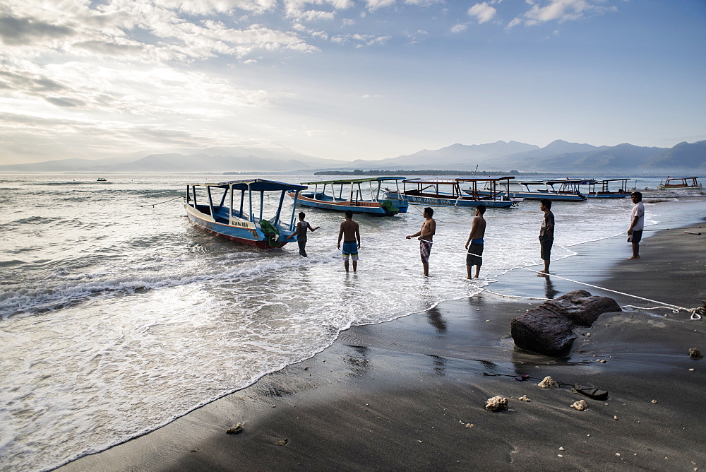 Local Men Secure Their Wooden Boat Against The Increasing Waves And Tide In Gili Air, Gili Islands, Indonesia