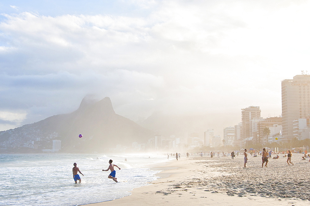 Two Men Playing Soccer In The Surf On Ipanema Beach