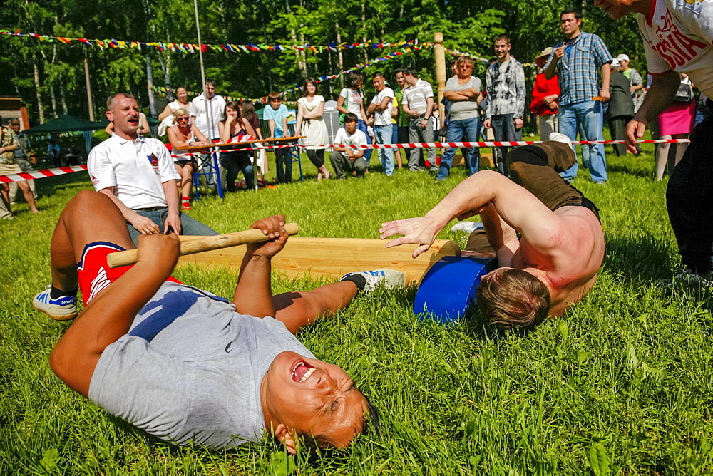 Men Performing Mas-wrestling Game On City Park With Traditional Stick