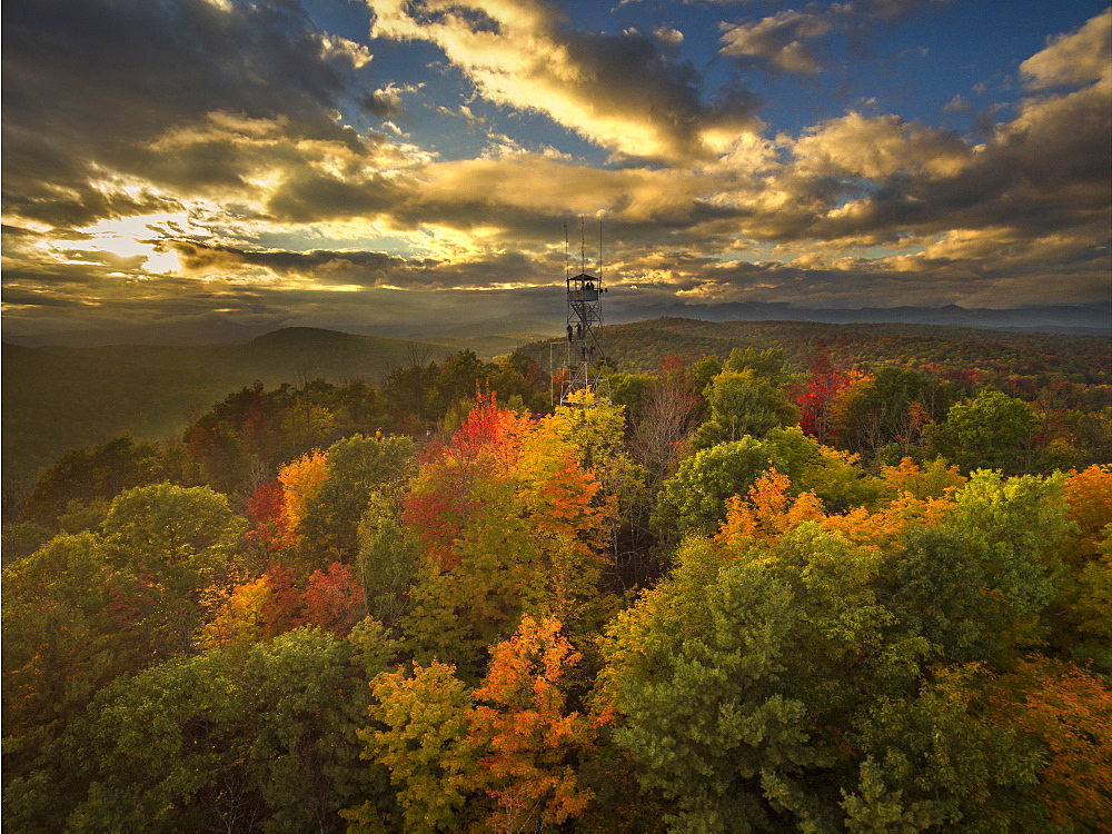 Fire Lookout Tower Surrounded By Autumn Trees With Adirondack Mountains In Background