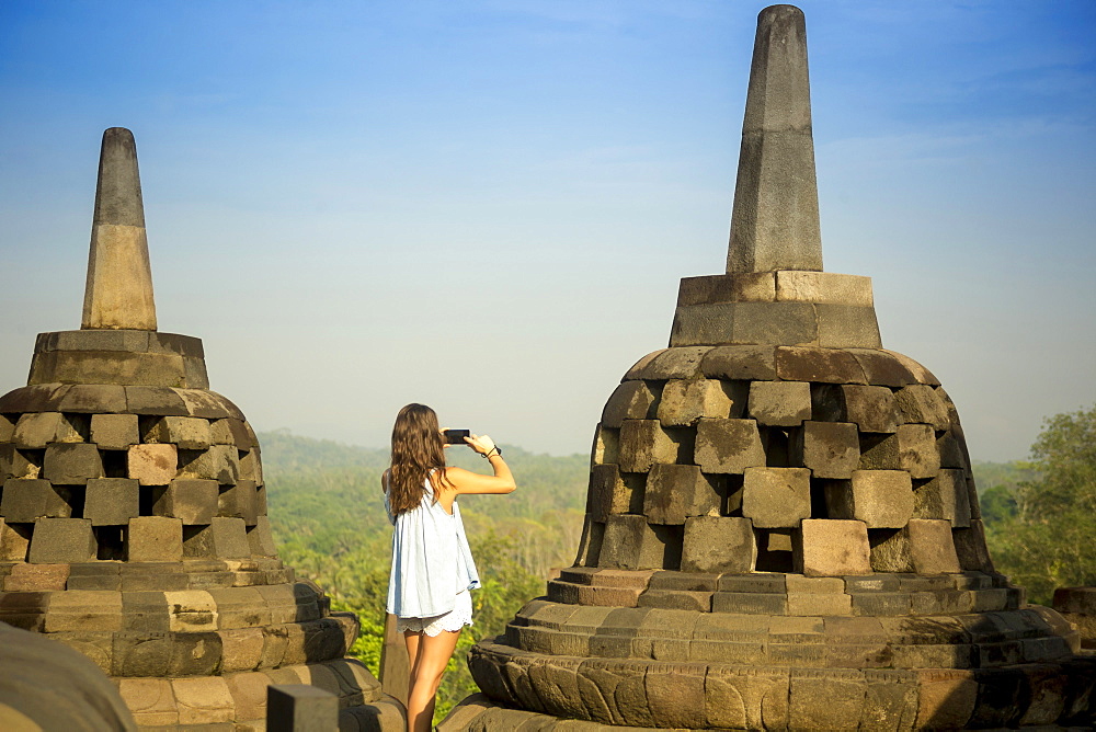 Woman Taking Pictures Of Stupas On Borobudur Temple In Indonesia