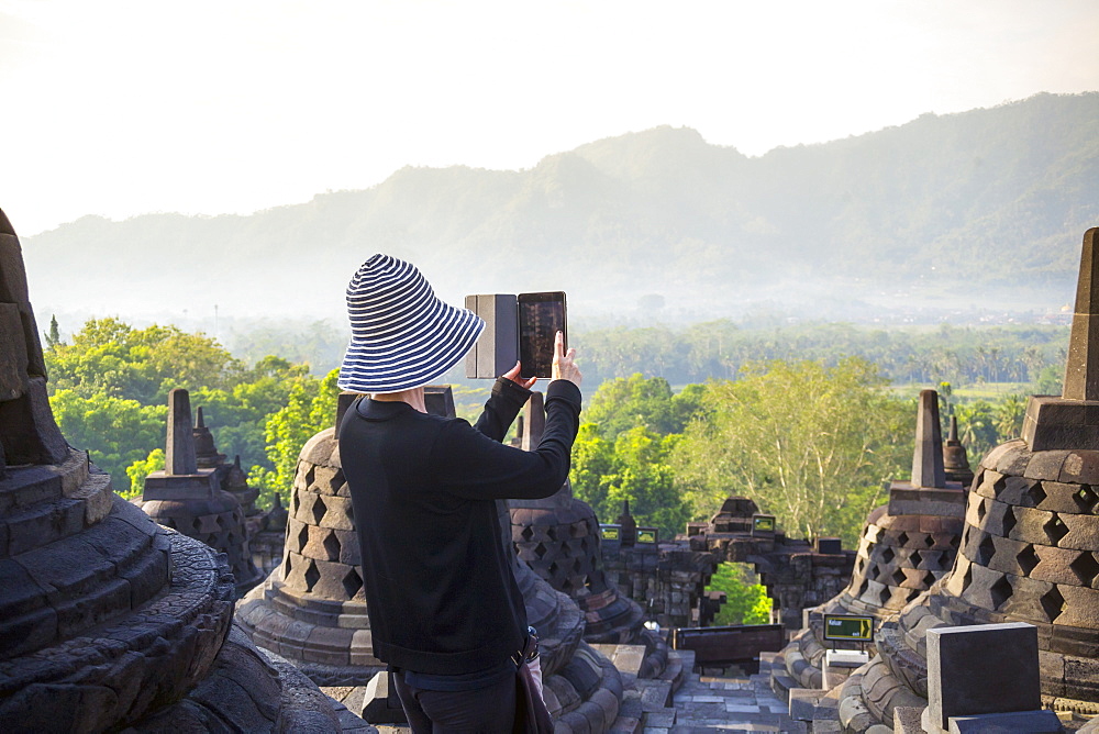 Person Taking Picture Of Borobudur Temple Using Digital Tablet In Indonesia