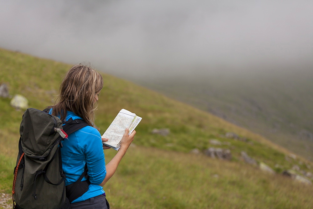 Female hiker consults map for direction