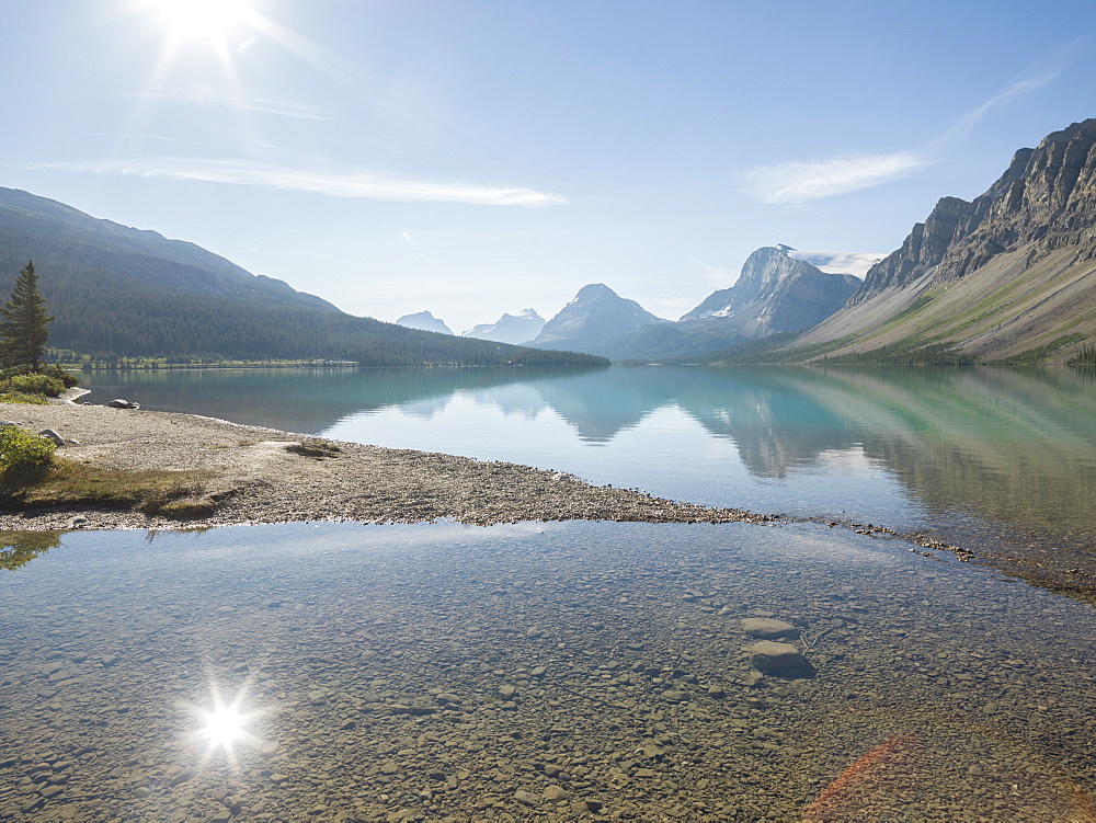 Reflection of mountains and sun in Bow Lake