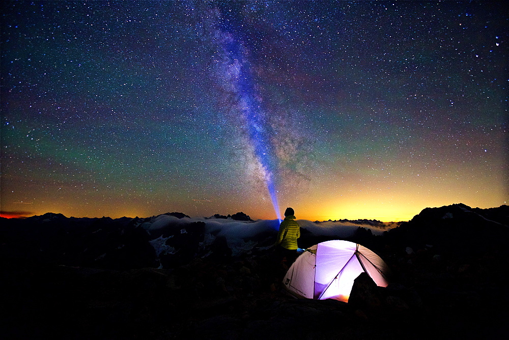Camper directs Flashlight Along The Milky Way