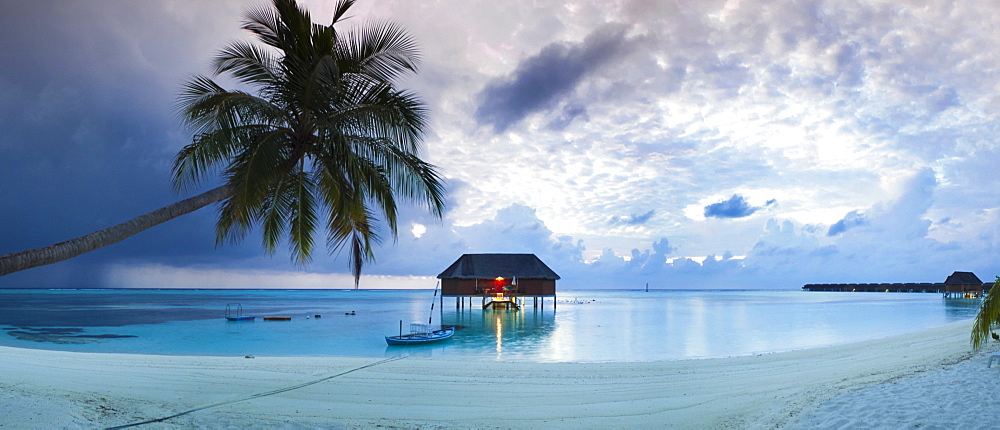 Stilt hut and boat in sea seen from beach on Meeru Island