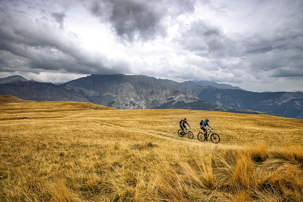 A Pair Of Mountain Bikers Riding On The Mercantour National Park, France