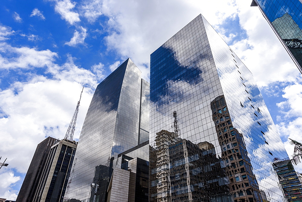 Clouds reflected on tall commercial buildings in Avenida Paulista, central São Paulo, Brazil