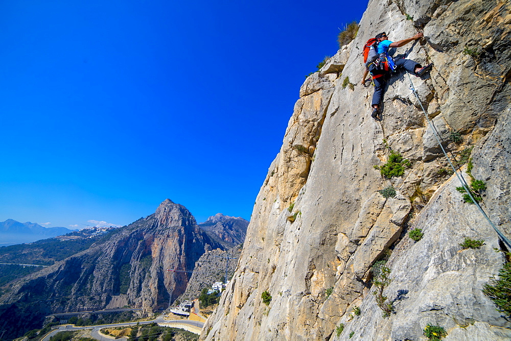 A man lead climbing a route at Sierra de Toix in Spain.