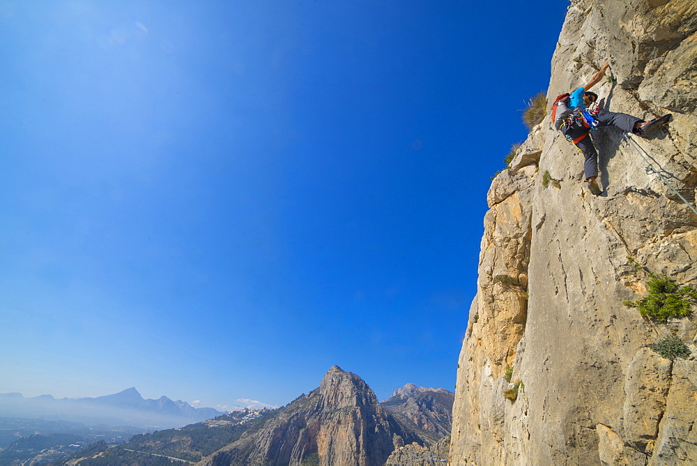 A man lead climbing a technical rock route in Costa Blanca Spain at Sierra de Toix.