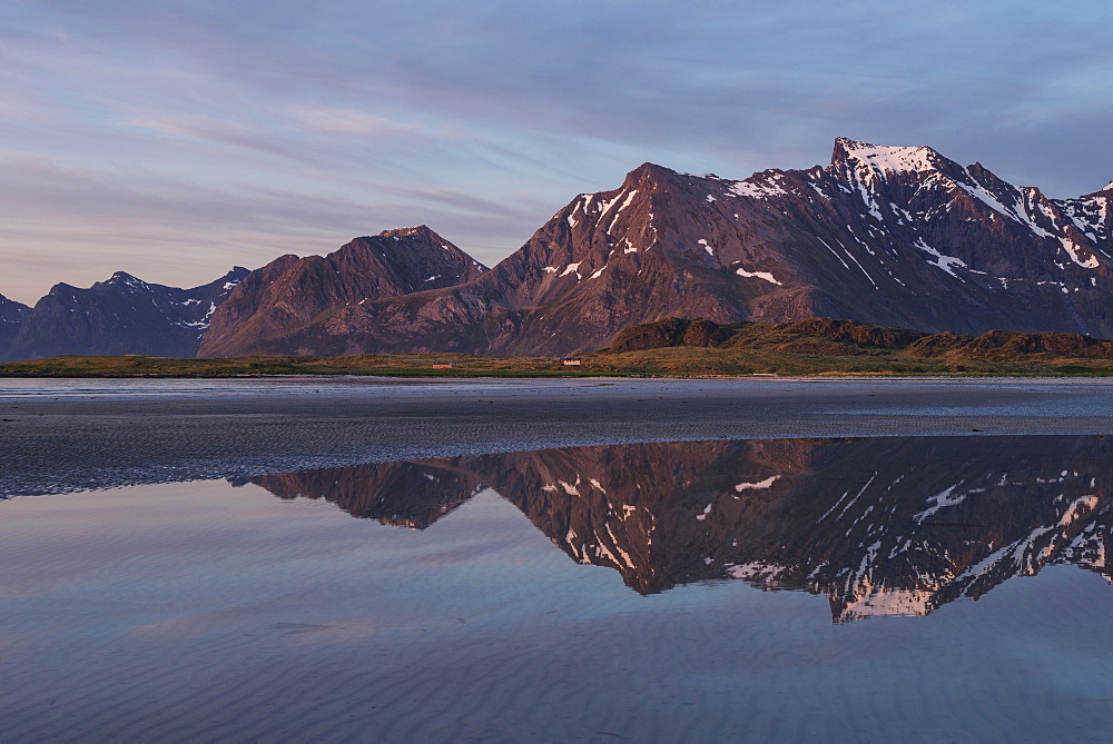Midnight sun mountain reflection on Ytresand beach, Moskenesøy, Lofoten Islands, Norway