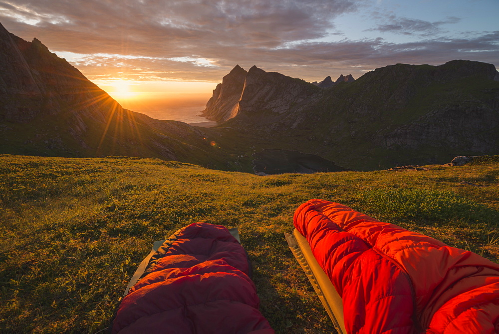 Watching colorful summer sunset over Bunes beach from sleeping bags, Moskenesøy, Lofoten Islands, Norway