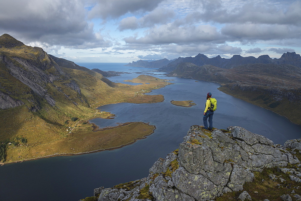 Female hiker takes in view over Selfjord from summit of Tverrfjellet, Lofoten Islands, Norway