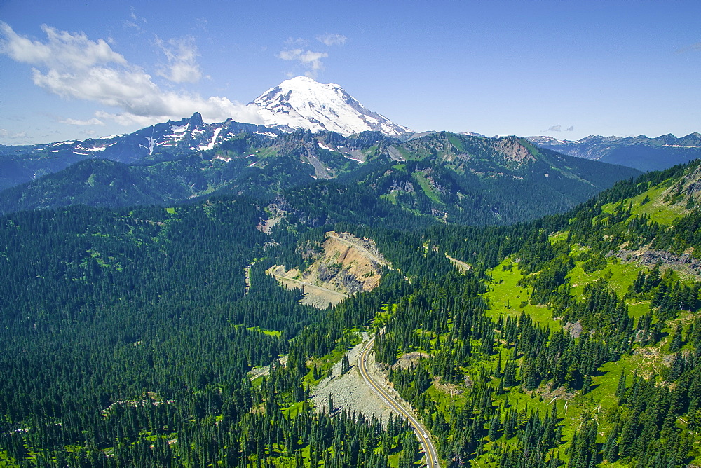 A mountainous country road winds towards Mount Ranier