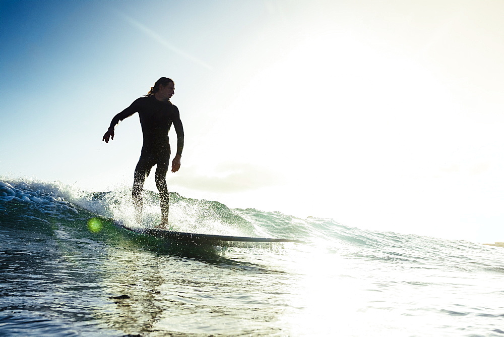 A man surfs a small wave on his longboard