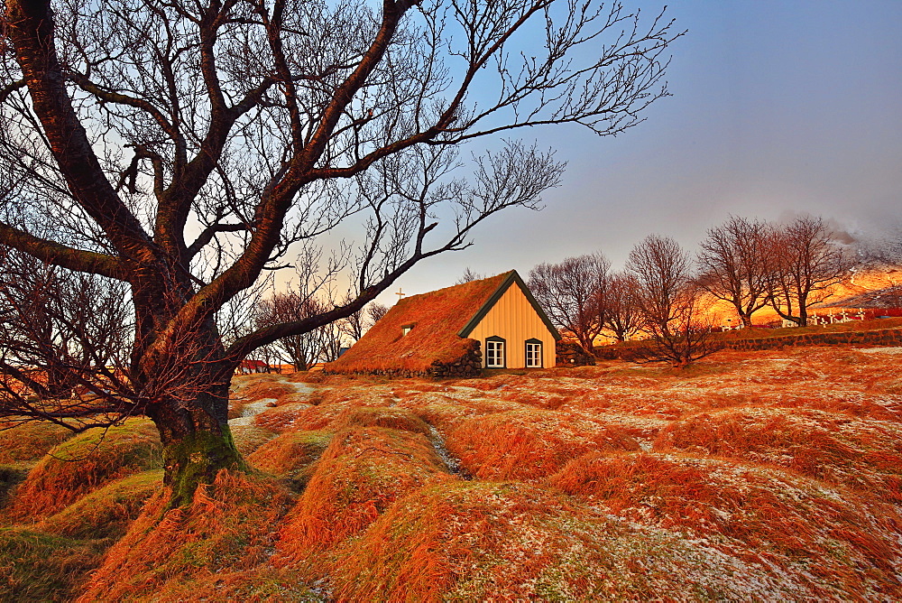 Hofskirkja turf-roofed church and gravemounds in winter light, Iceland