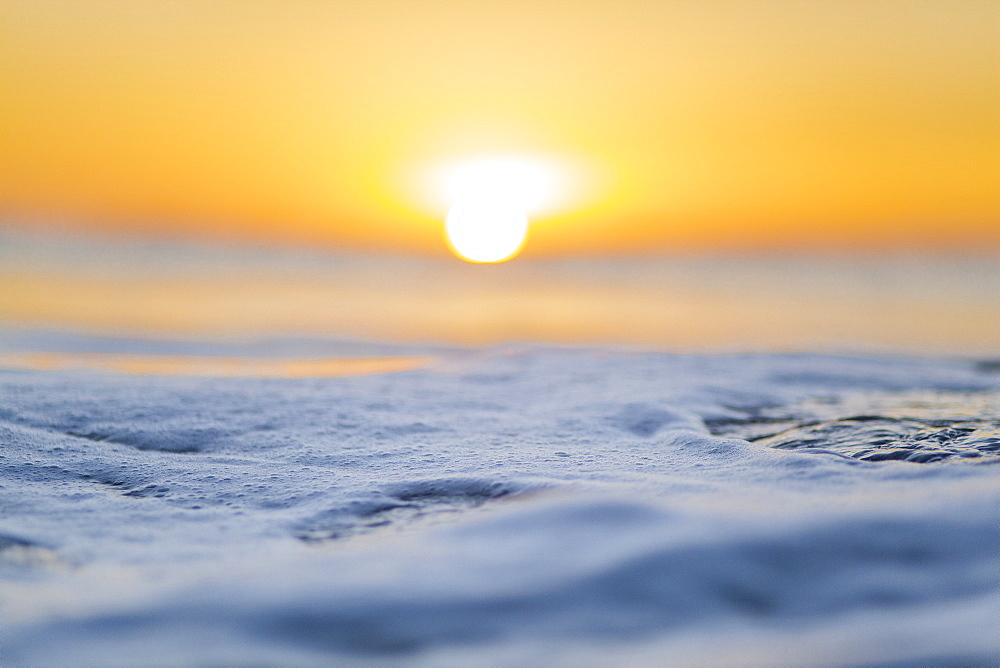 Macro focusing on the ocean, during sunrise.