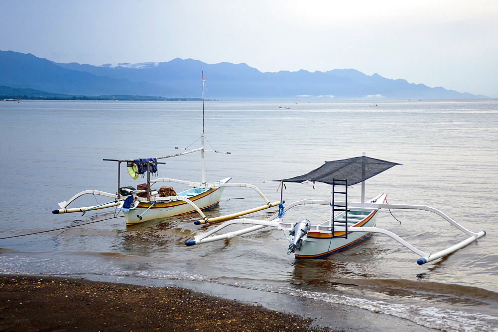 Photograph of traditional wooden outrigger boats on beach, Lovina, Bali, Indonesia