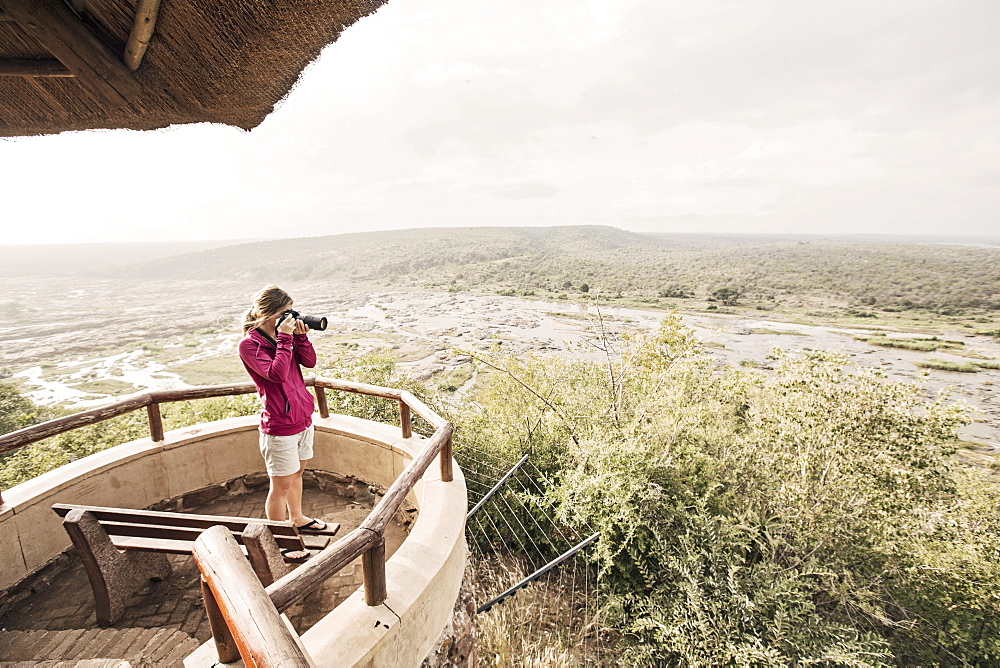 Female photographer taking picture at overlook in Kruger National Park, South Africa