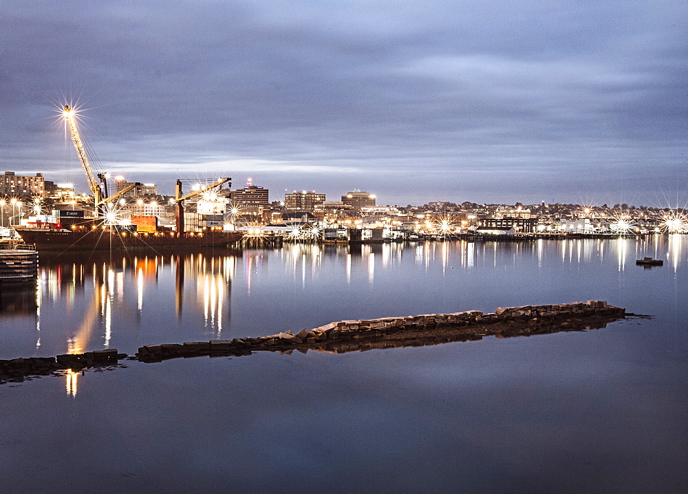 Portland, Maine's harbor is lit up in a long exposure at night.