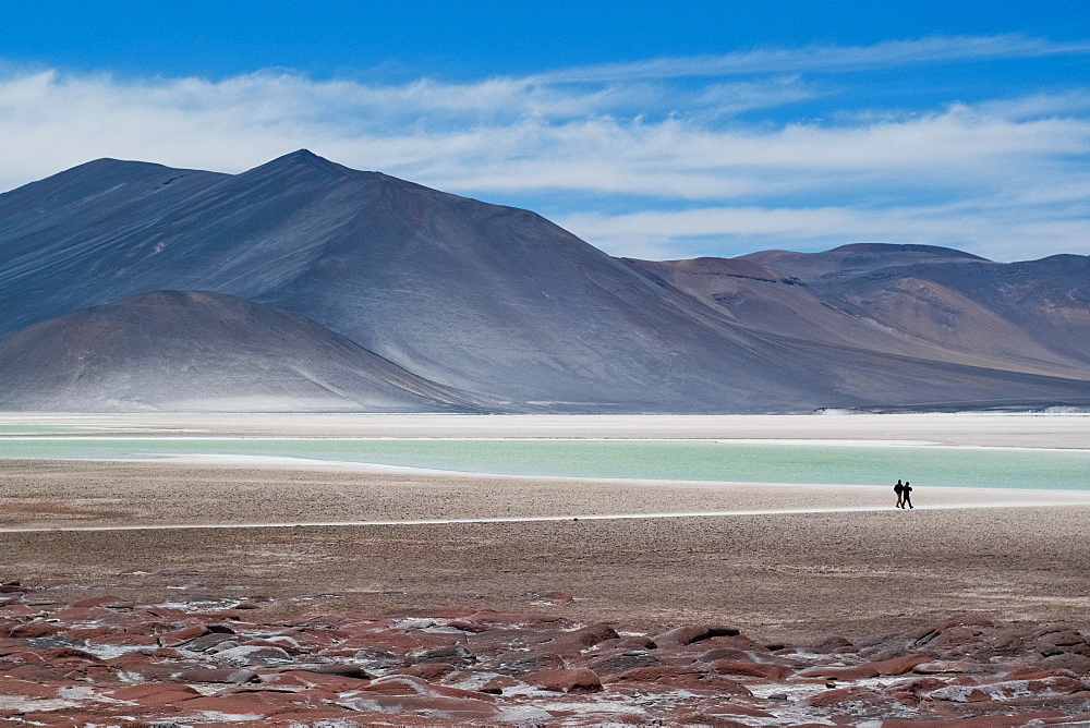 Silhouette of two people by lakes at Piedra Rojas on Altiplano in Atacama Desert, Chile