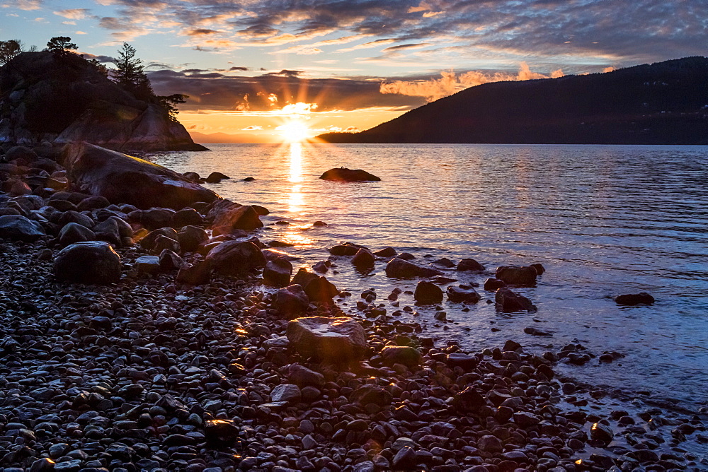 The sun sets on a winter night of the ocean as seen from Whytecliff Park in West Vancouver, British Columbia.