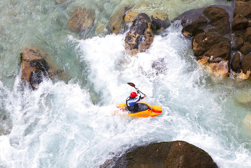 Male kayaker crossing whirlpool in green colored Soca river near Bovec, Slovenia