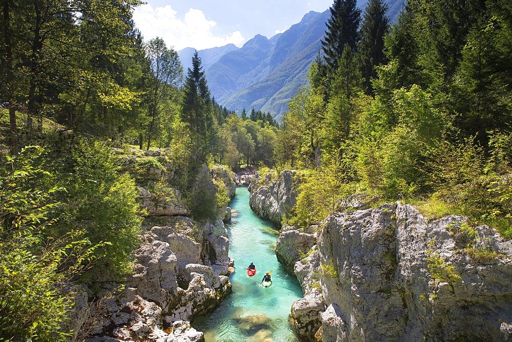 Kayakers on Soca river originating in Trigval mountains. The river is famous for all kinds of white water activities, Triglav National Park, Slovenia