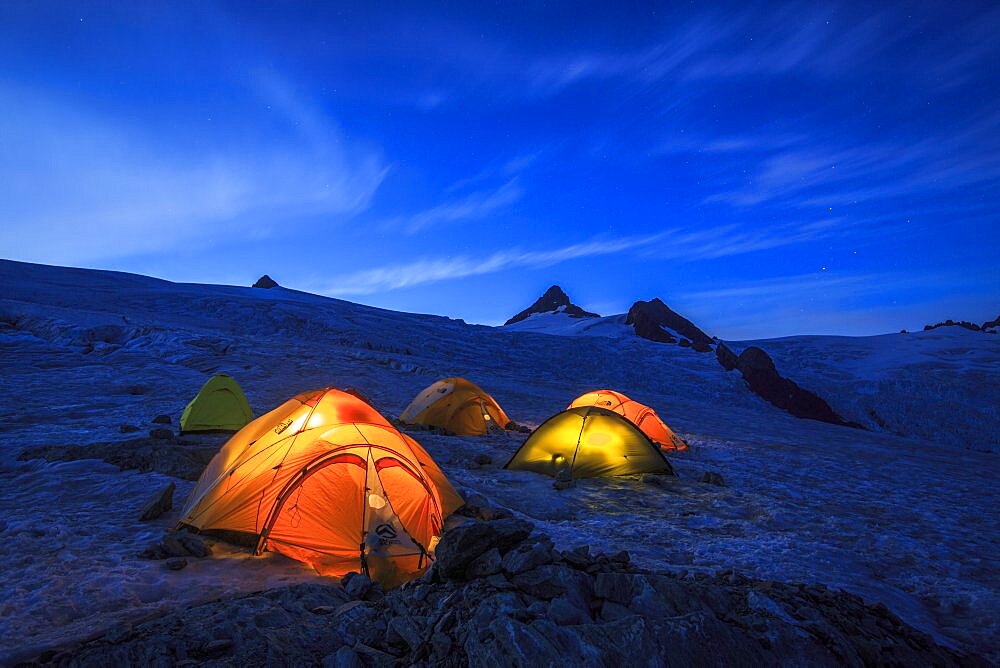 Glacier campsite with illuminated tents at Mount Shuksan, North Cascades National Park, Washington State, USA