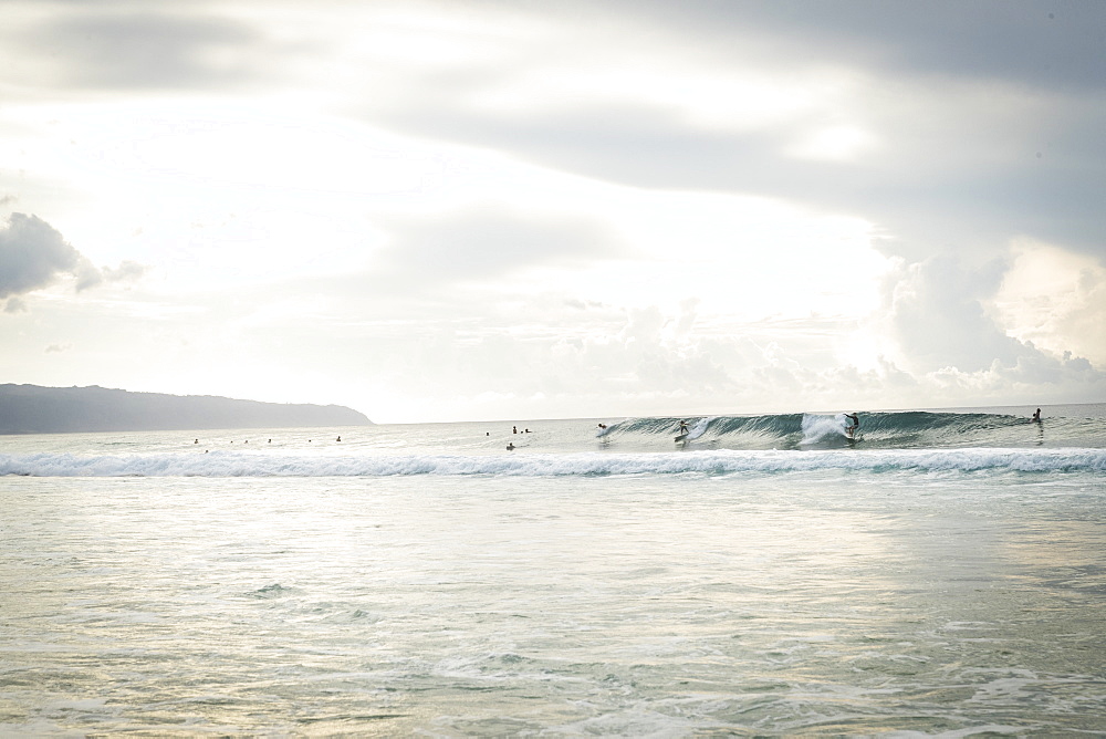 Surfers riding wave in Pacific Ocean, Oahu, Hawaii Islands, USA