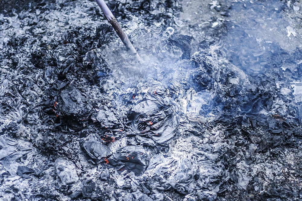 Stick in stack of ashes on ground, Cat Ba Island, Vietnam