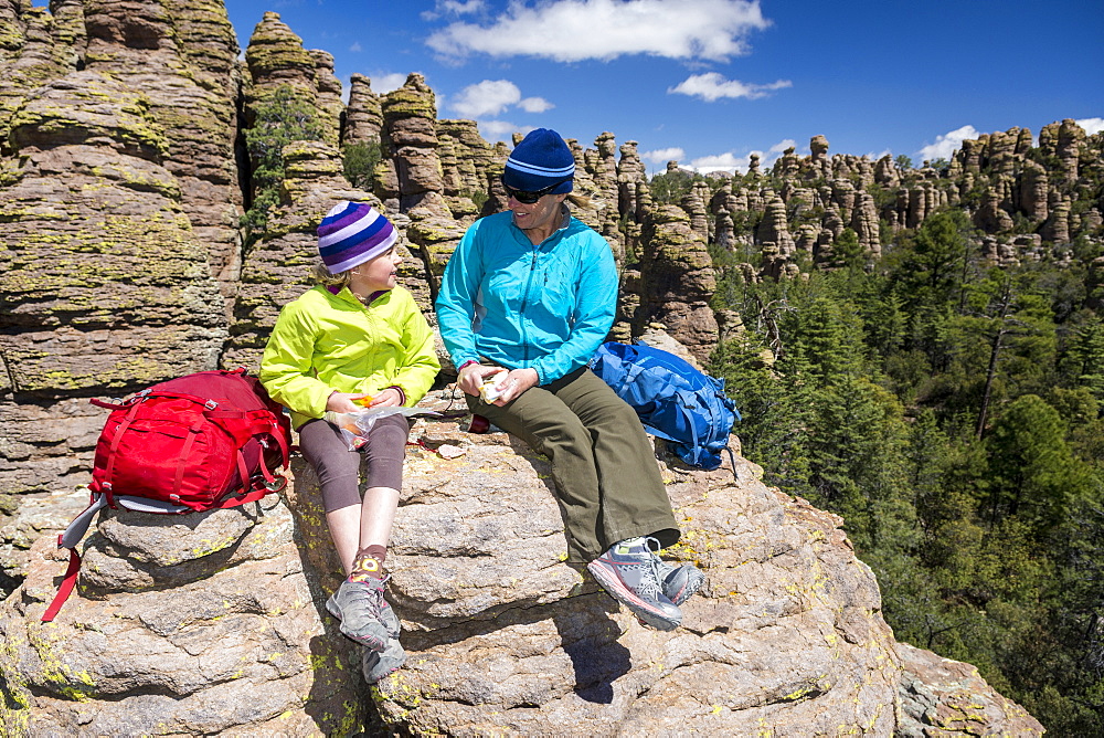 Mother and daughter resting and eating while hiking in Heart of Rocks, Chiricahua National Monument, Willcox, Arizona, USA