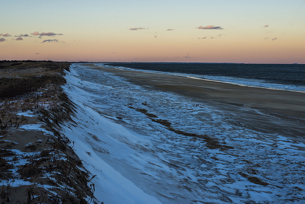 Snow covered dunes along the Atlantic Ocean at sunset on Plum Island, Parker River Wildlife Refuge, Newburyport, Massachusetts, USA