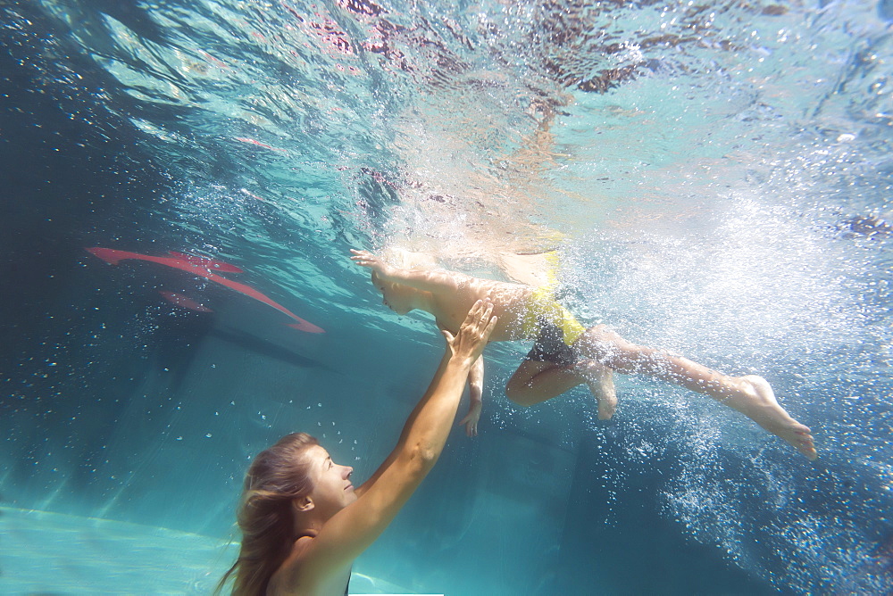 Underwater view of mother and son swimming in swimming pool