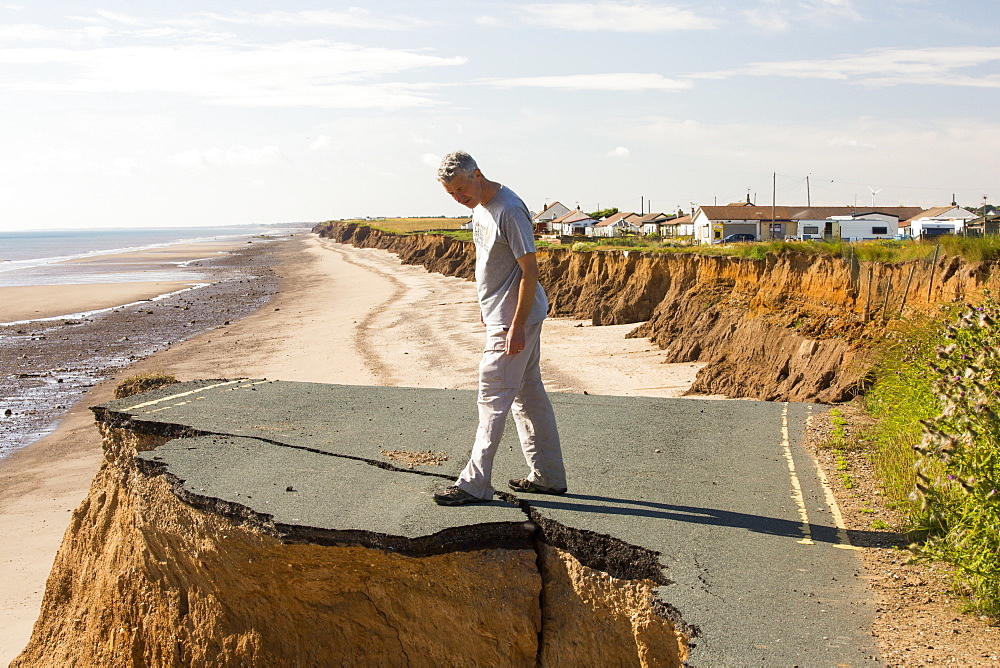 A collapsed coastal road at between Skipsea and Ulrome on Yorkshires East Coast, near Skipsea, UK. The coast is composed of soft boulder clays, very vulnerable to coastal erosion. This section of coast has been eroding since Roman times, with many villages having disappeared into the sea, and is the fastest eroding coast in Europe. Climate change is speeding up the erosion, with sea level rise, increased stormy weather and increased heavy rainfall events, all playing their part.