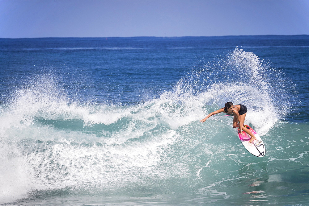 Full length shot of single woman surfing in sea