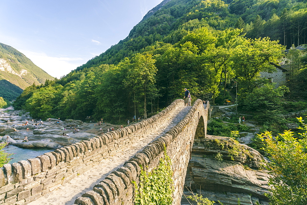 Mountainscape with stoned bridge across river in Alps in summer, Verzasca, Ticino, Switzerland