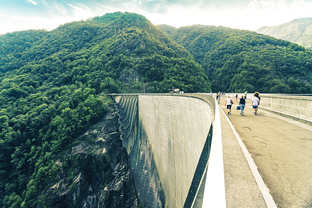 Landscape with forest and tourists walking on Verzasca Dam, Verzasca, Ticino, Switzerland