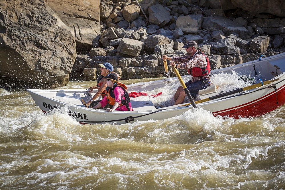 Man and two women sailing through rapids of Green River in Desolation Canyon, Utah, USA