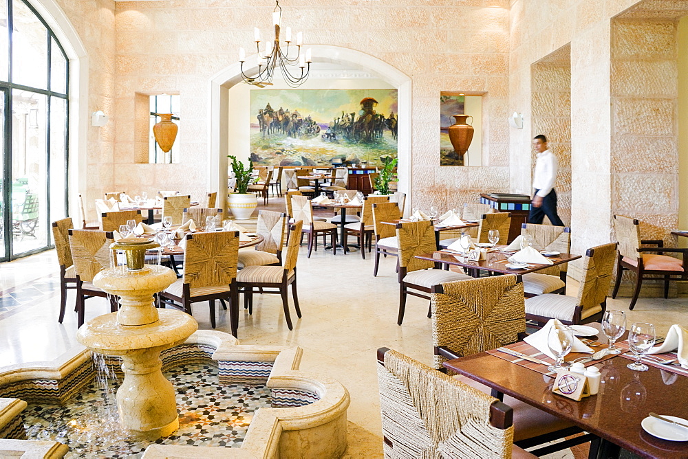 Waiter walking across luxurious Al Saraya Restaurant in Movenpick Dead Sea Spa and Resort, Madaba Governorate, Jordan