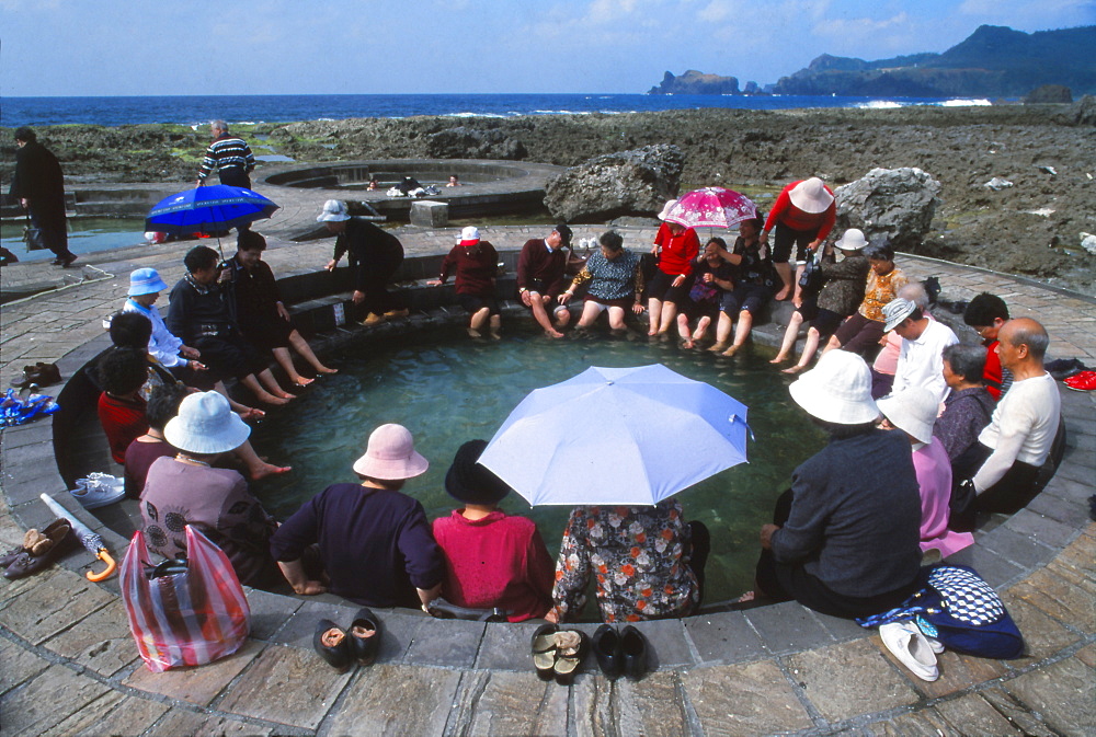 People enjoying saltwater hot springs on sunny day, Lu Tao, Lu Tao Island, Taiwan