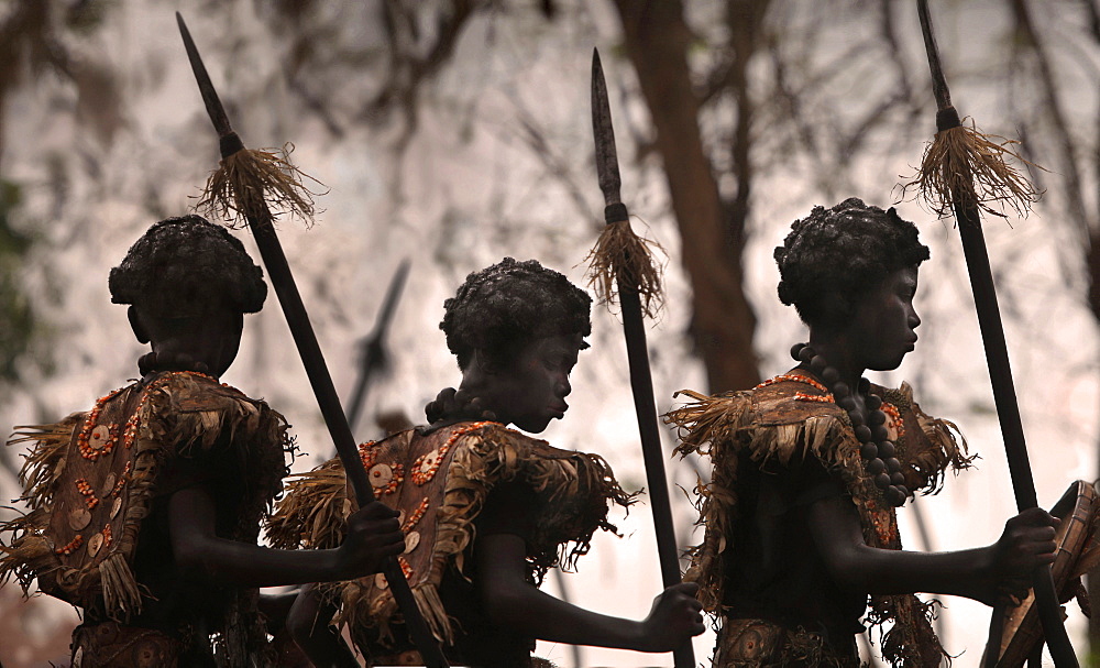 Three children wearing tribal African costumes on blurred background at Ati Atihan festival, Kalibo, Aklan, Panay Island, Philippines