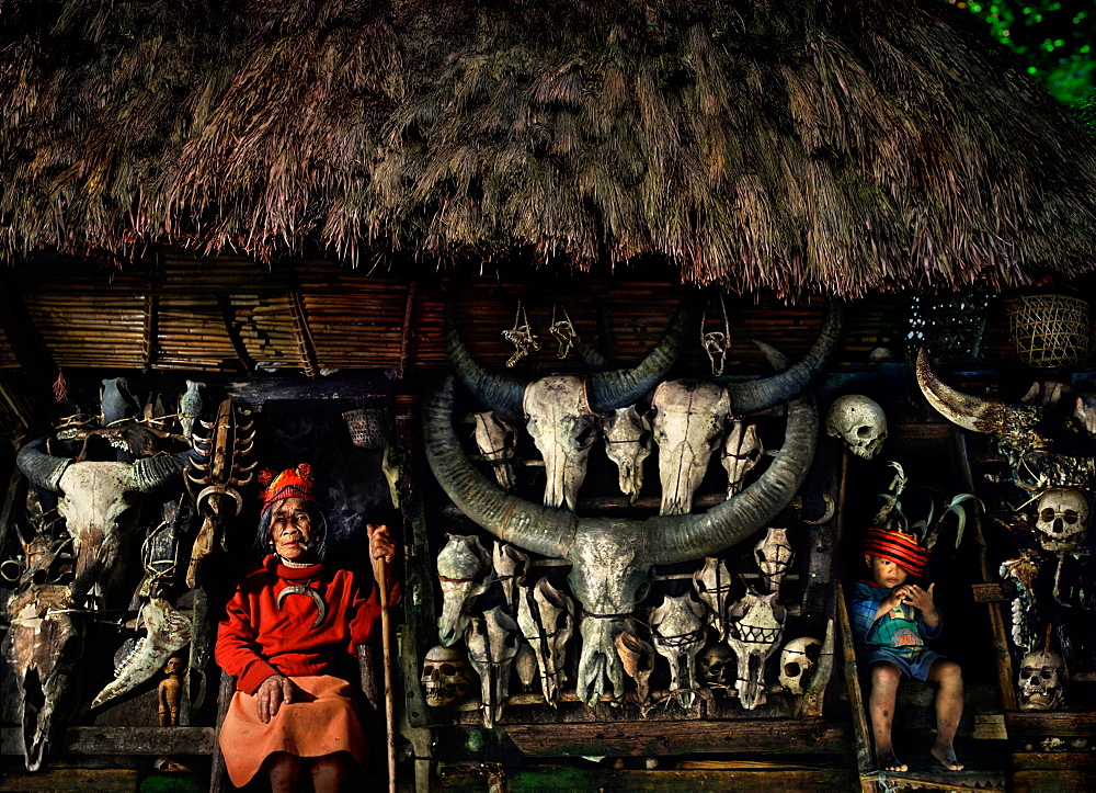 Senior woman and boy with human and water buffalo skulls, Banaue, Ifugao, Philippines