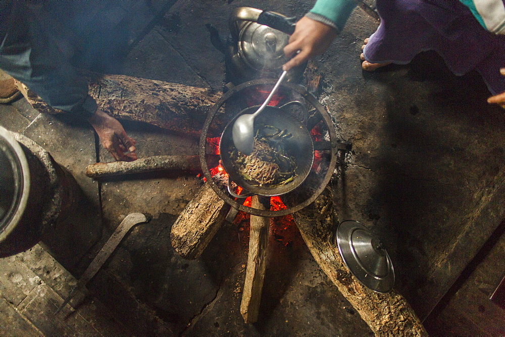 Directly above view of people cooking indoors over small campfire, Myanmar, Shan, Myanmar