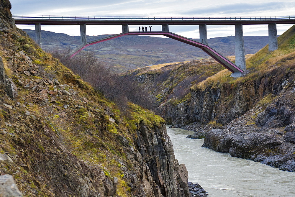 Silhouettes of four people standing under Ring Road bridge over Jokulsa a Dal river, Hringvegur, Iceland