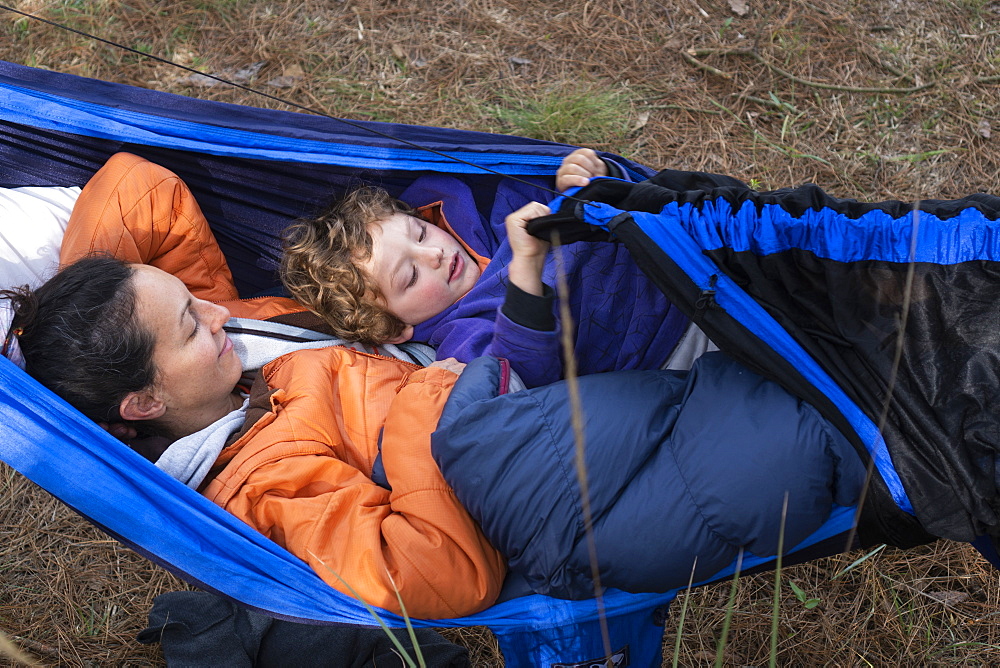 Mom and her son laying in hammock while camping in Rancho Santa Elena, Hidalgo, Mexico