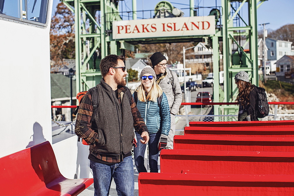 Group of happy friends getting off ferry, Peaks Island, Maine, USA