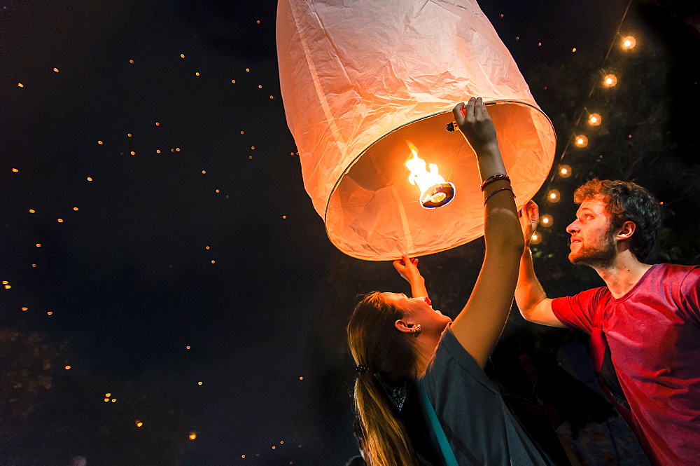 Man and woman holding paper lantern during Yi Peng festival, Chiang Mai, Thailand