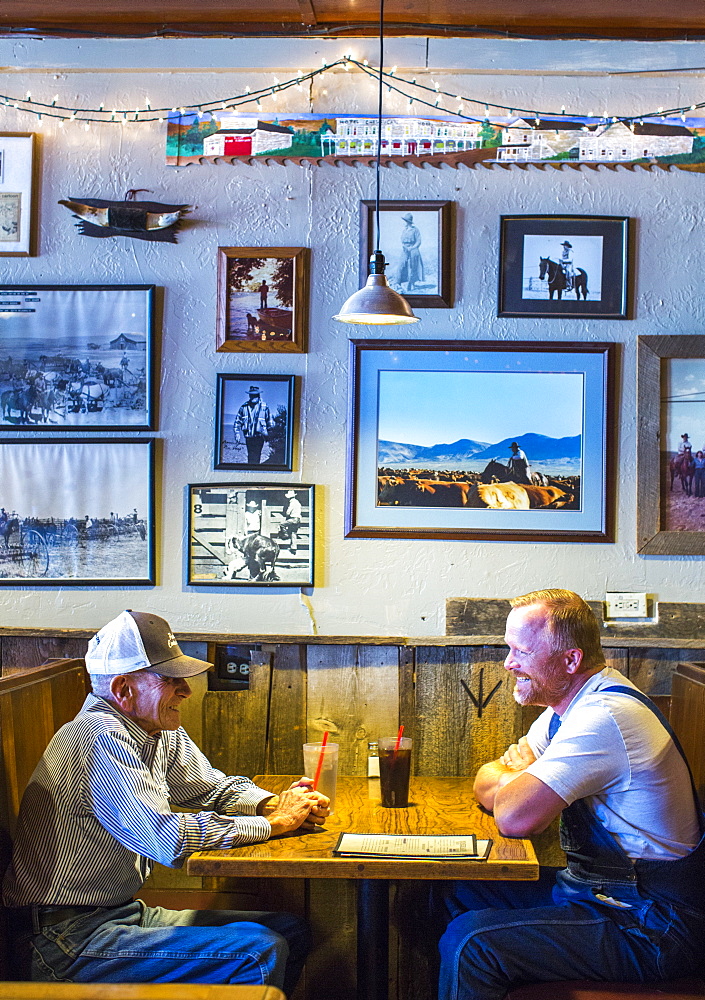 Side view of two mature men sitting at table in restaurant, Paisley, Oregon, USA