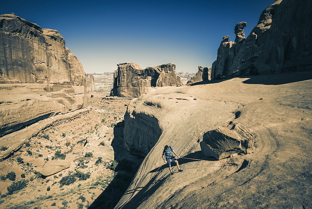 Distant view of man?rappelling?in??U-Turn Canyon, Arches National Park, Moab, Utah, USA